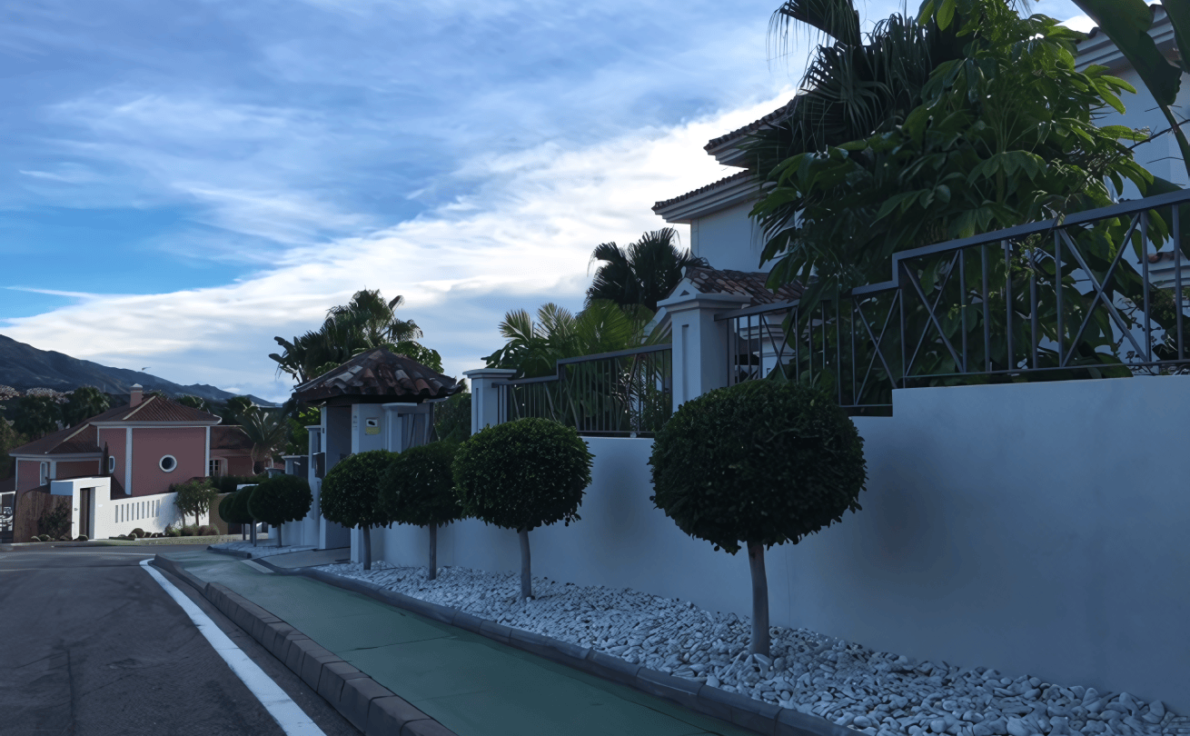 Pathway winding through lush greenery and tall trees in La Cerquilla garden.